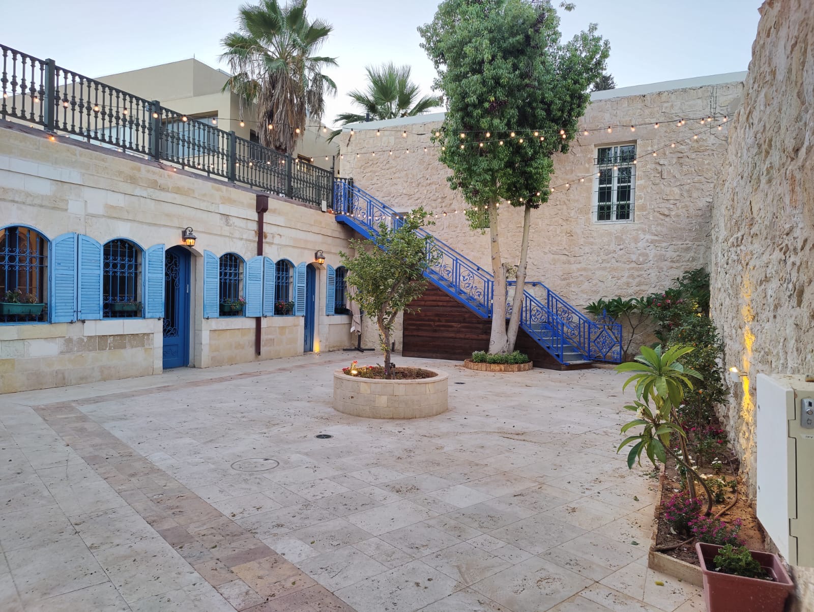החצר ההיסטורית של JOSEPH עם תריסים כחולים ומדרגות אבן
